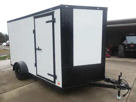 White enclosed trailer with black trim and black door hardware, side access door, single axle